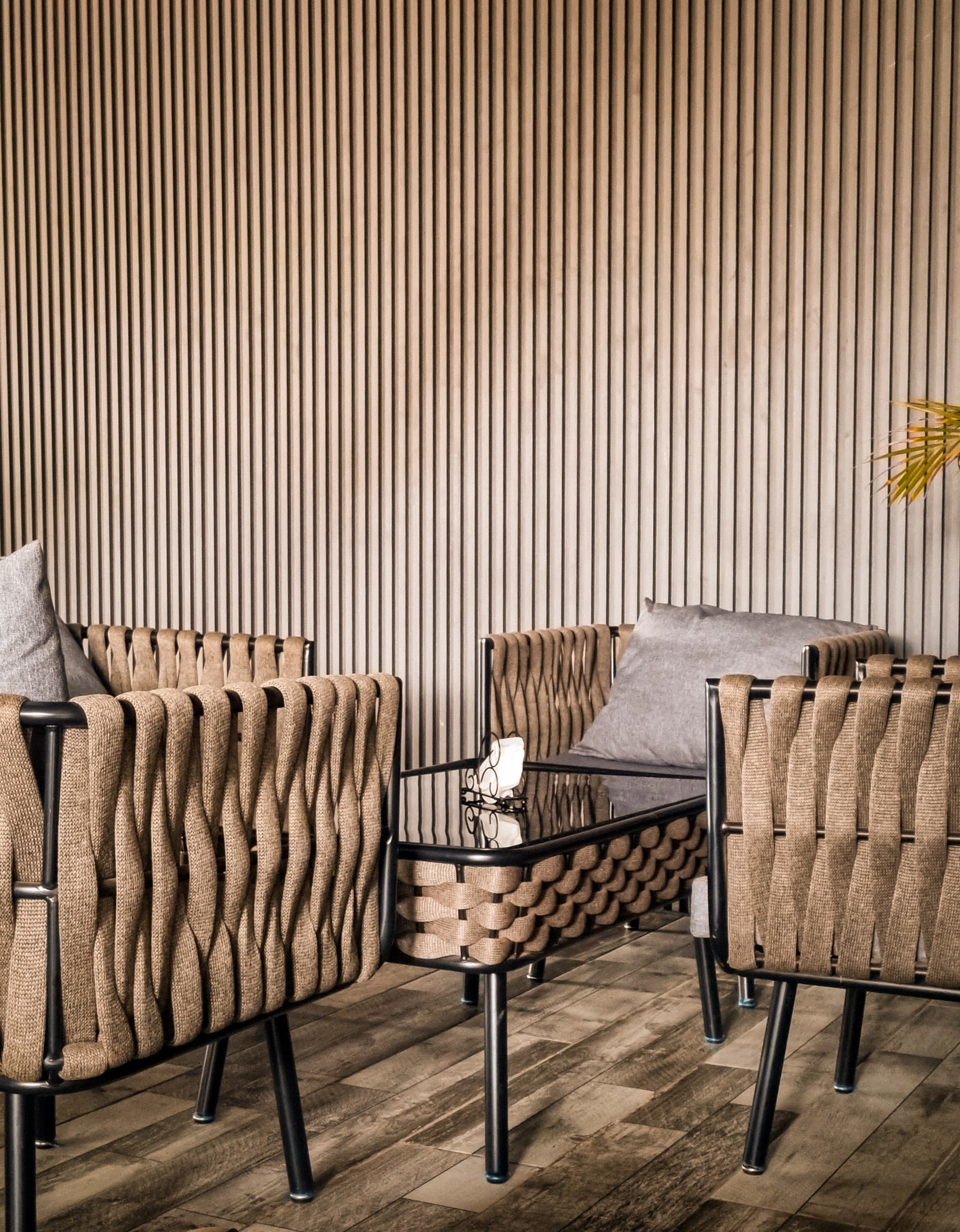 Modern woven furniture against wood paneling