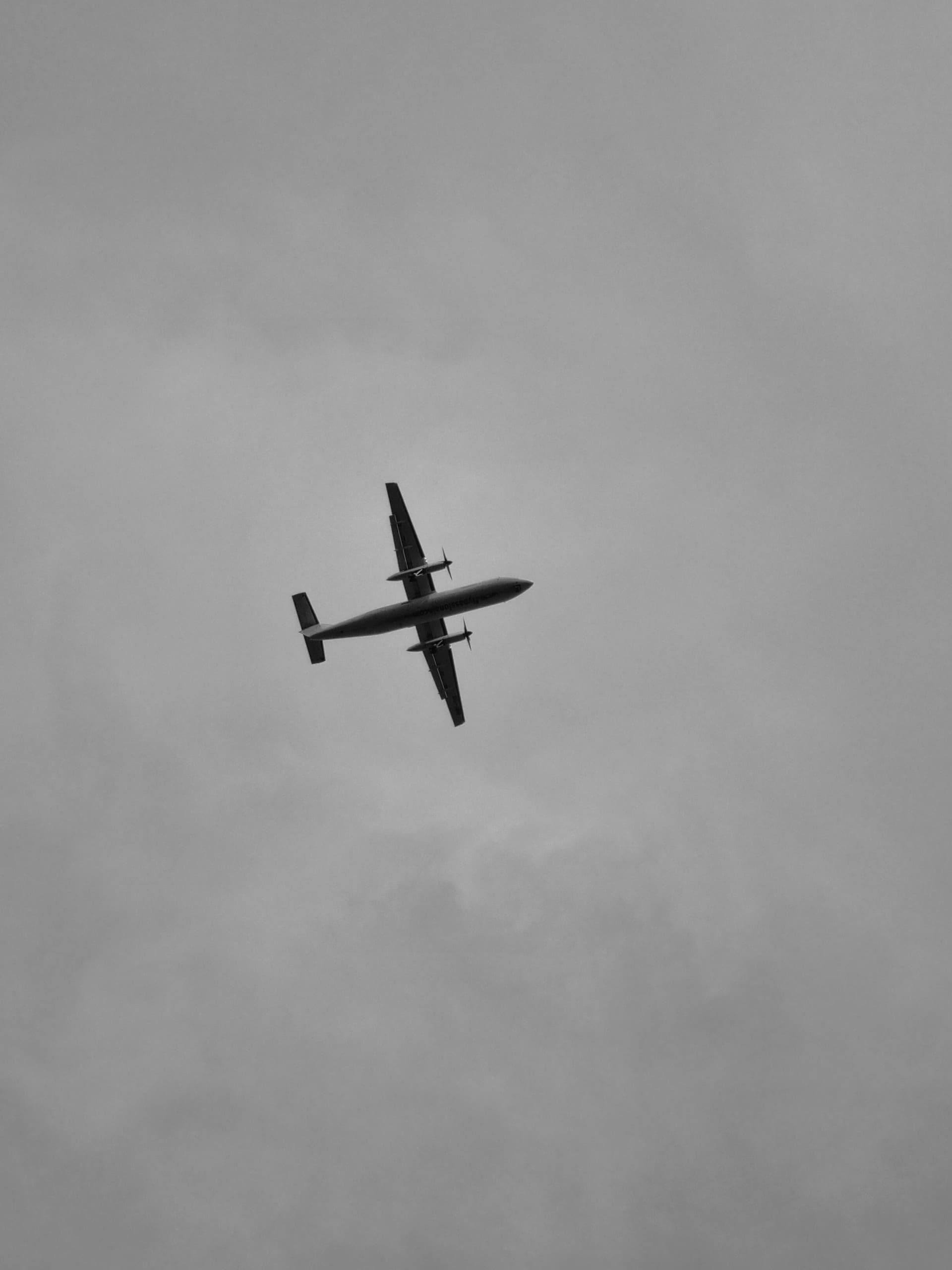 Airplane silhouetted against a cloudy sky