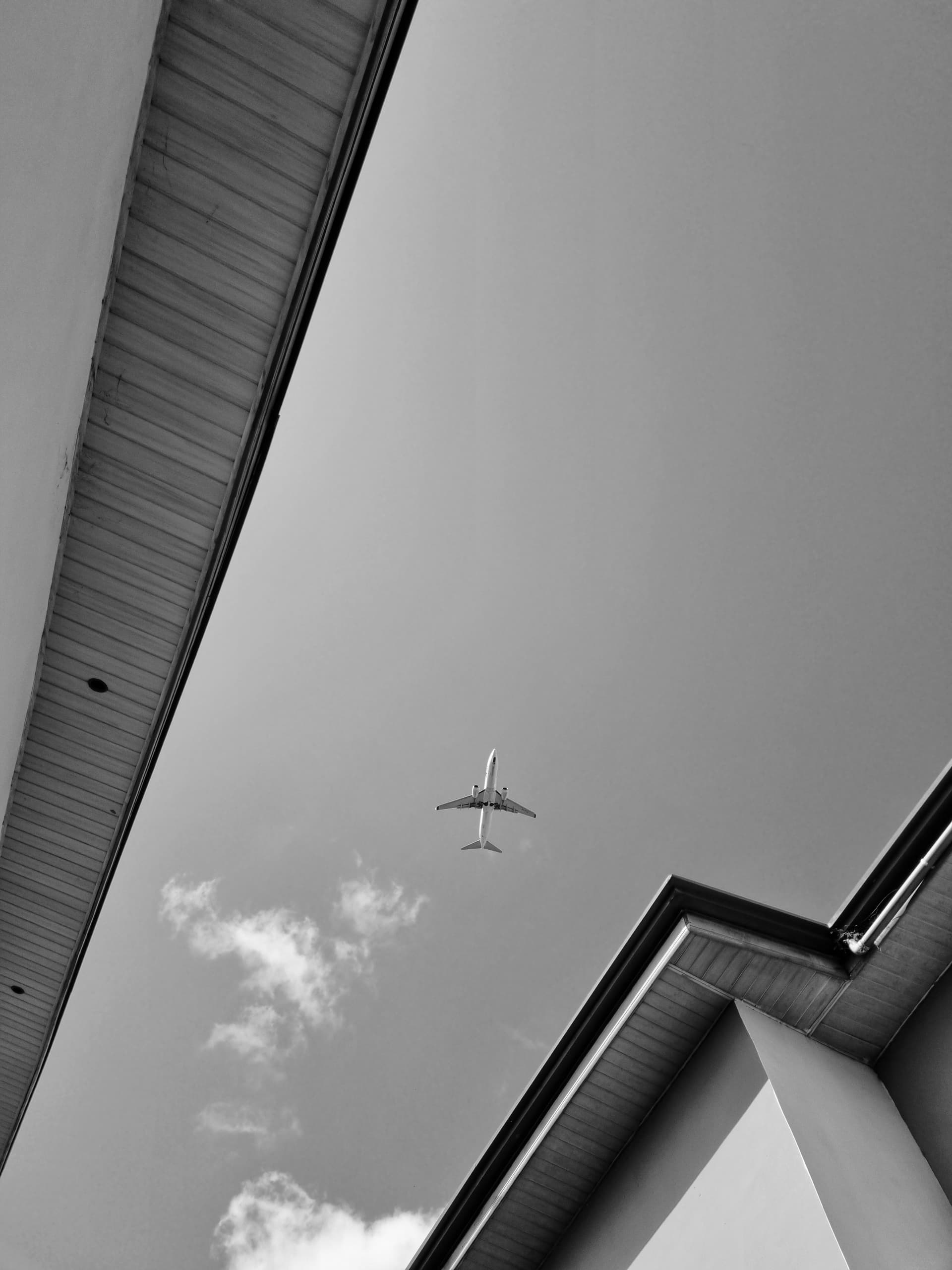 Airplane framed between two rooflines