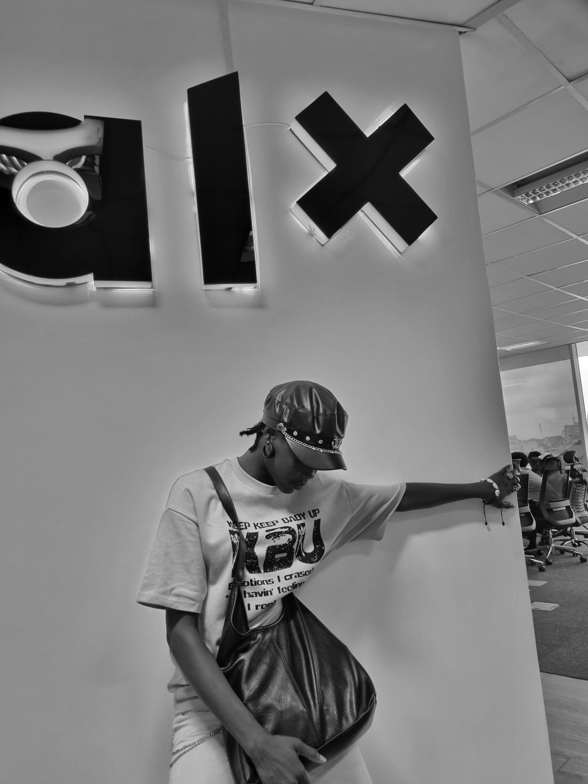 Person leaning against a wall with ALX logo