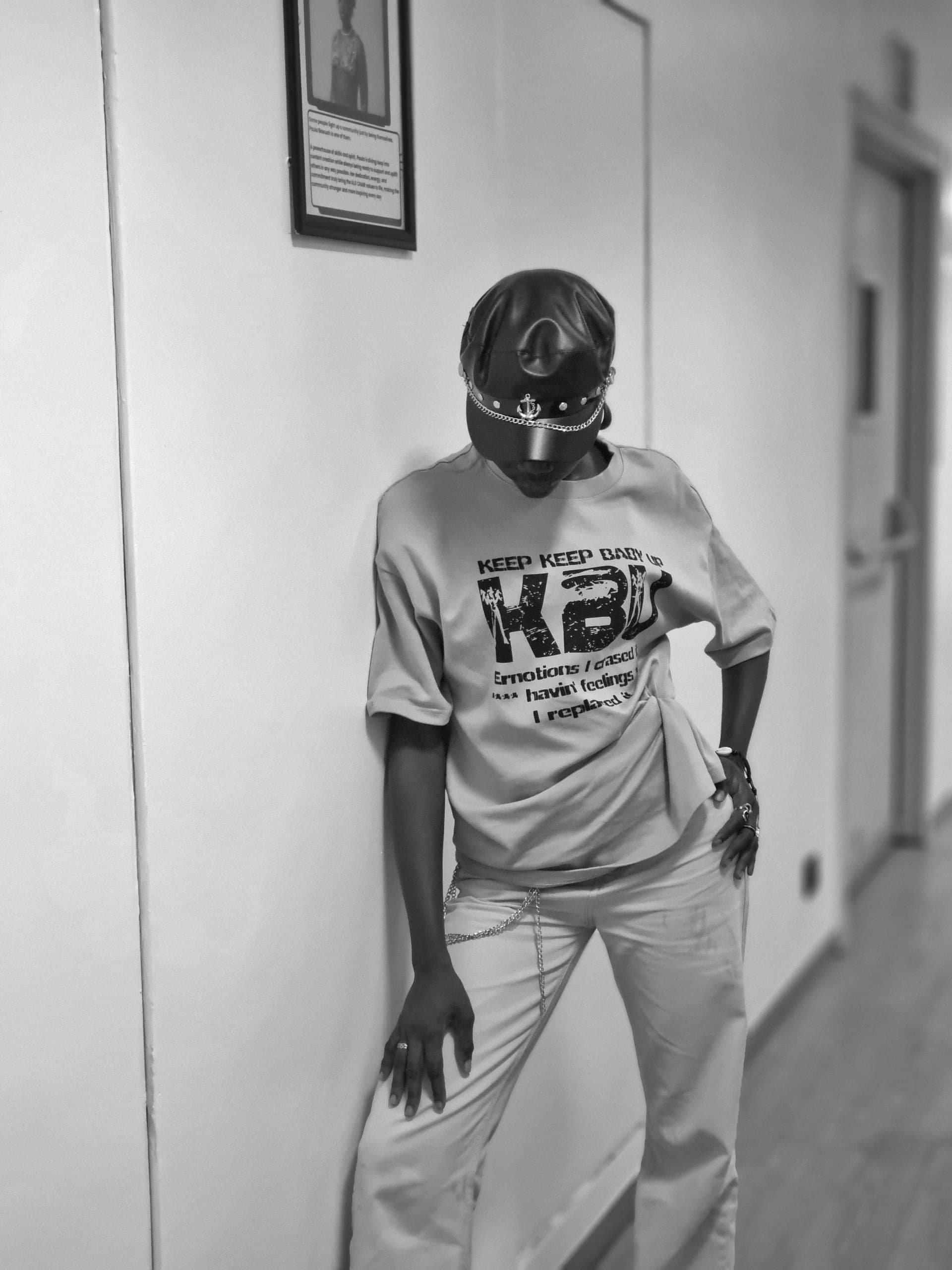 Person in a leather cap standing in a hallway