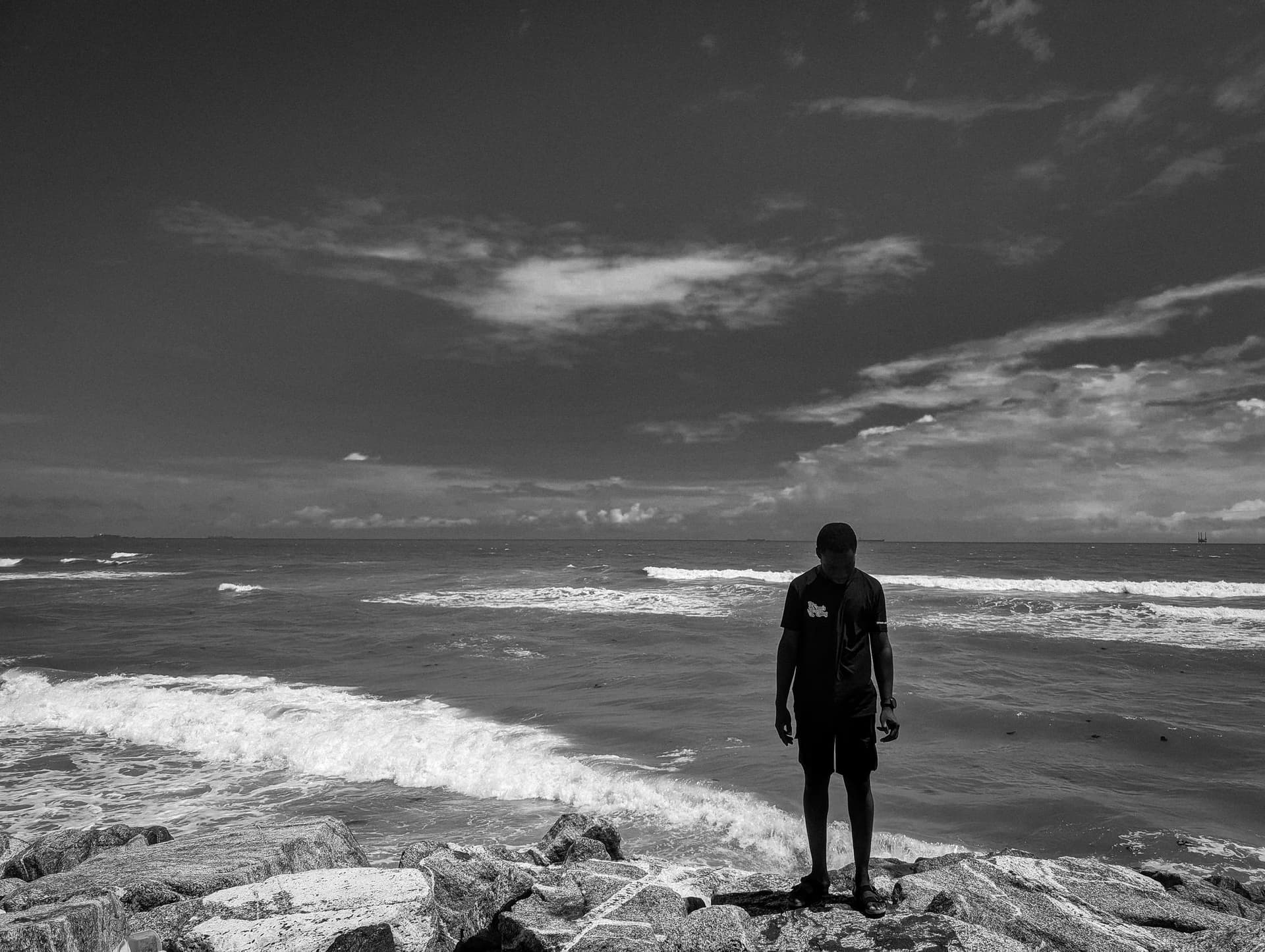 Person standing on rocks by the sea