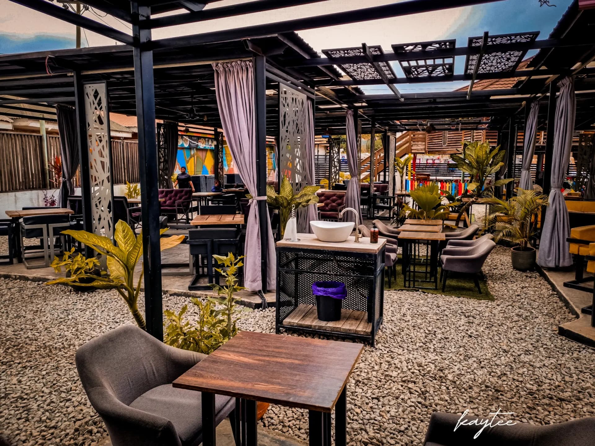 Outdoor restaurant seating area with gravel and modern furniture